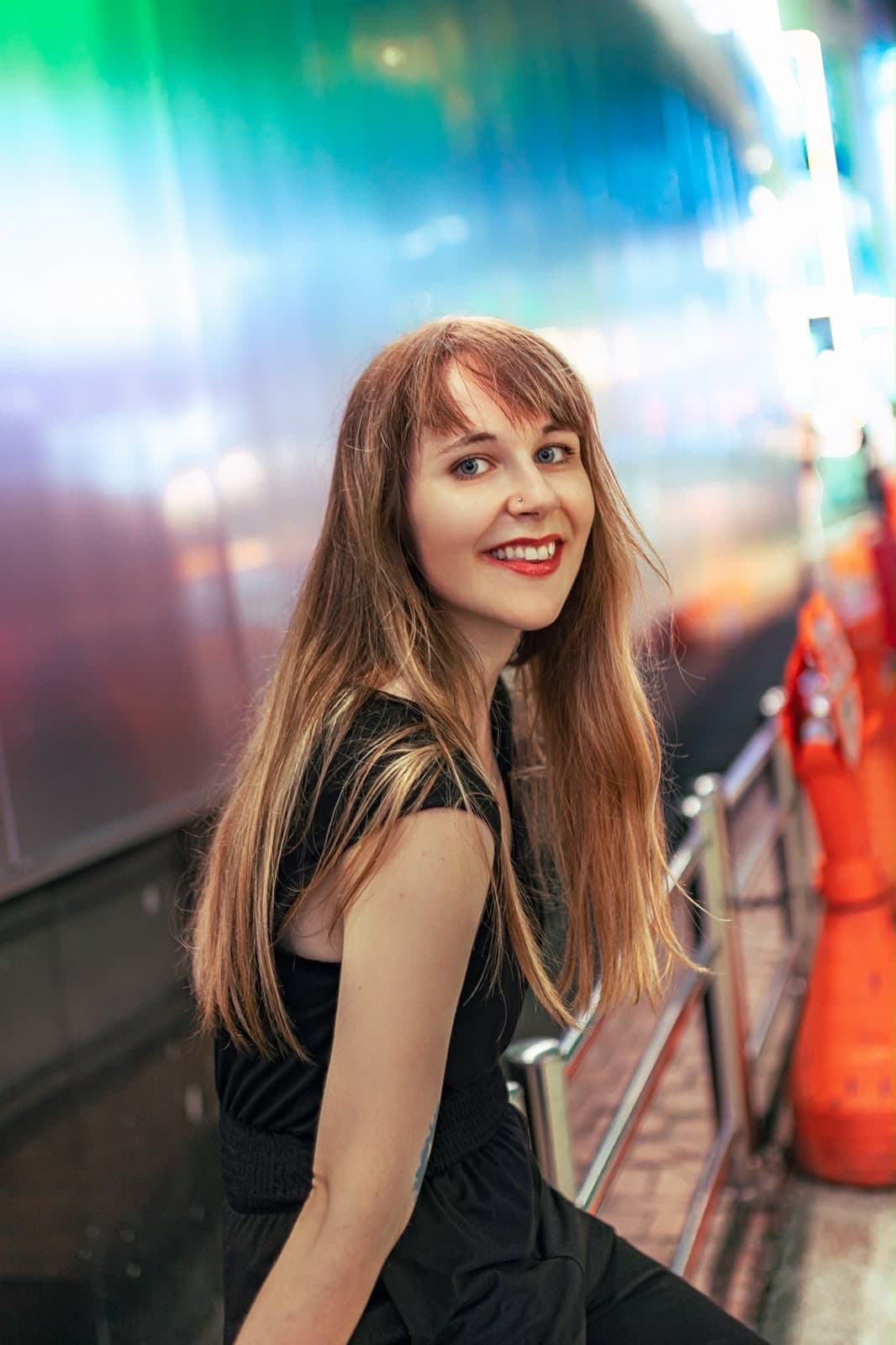 Lena lächelt vor bunten Neonlichtern